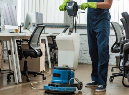cropped view of cleaner washing floor in office with cleaning machine